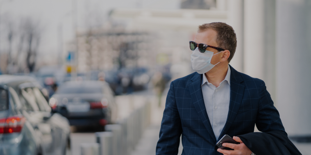 A man walking in the city with mask due to COVID19